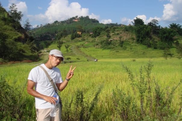 Jenkin Lee standing beside rice fields in Nepal